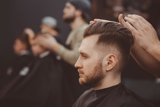 man getting his hair done from a barber