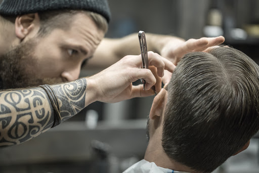 man getting a straight edge cut from a barber